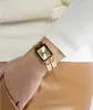 A close-up shot of a woman's wrist wearing a gold Guess watch. Náhled obrázku produktu