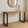 A wooden console table with black metal legs is shown in a room with a mirror and a vase of flowers. Produktbild-Vorschau
