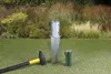 A ground sleeve, hammer, and a green cap are laid out on a grassy lawn with a blurred background of plants and tall grasses. Produktbild-Vorschau