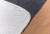 Close-up of a blanket with different colored sections and a stitched edge. Produktbild-Vorschau