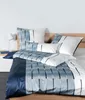 A neatly made bed with blue and white striped bedding. Voir les images du produit