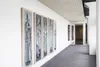 A hallway gallery displaying several tall, narrow paintings of figures. Náhľad obrázku produktu
