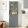 A gray bathroom cabinet with glass doors, filled with toiletries, stands next to a white vanity with a sink and mirror. Náhľad obrázku produktu