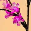 A close-up of pink LED flowers on a black branch. Produktbild-Vorschau