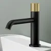 A black faucet with a gold textured top sits on a white sink. Podgląd zdjęcia produktu