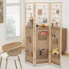 A room divider with storage pockets and hanging clips, set up in a room with a chair and a cabinet. Voir les images du produit