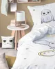 A bedroom scene featuring bedding with a Harry Potter theme, a decorative pillow, and a bedside table with a lamp and hat. Produktbild-Vorschau