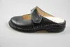 A black leather clog is shown on a white background. Podgląd zdjęcia produktu