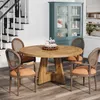 A round wooden dining table set with chairs, in a room with stairs and a hutch. Anteprima dell’immagine prodotto
