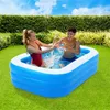 Two young people are splashing water in an inflatable pool in a backyard. Produktbild-Vorschau