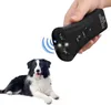 A black ultrasonic dog bark deterrent device is held in a hand above a border collie dog. Podgląd zdjęcia produktu