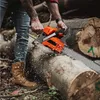 A person is using a chainsaw to cut a large log in a forest setting. Produktbild-Vorschau