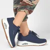 A person wearing blue Skechers Uno Stand On Air sneakers and camouflage pants. Anteprima dell’immagine prodotto