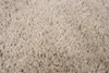 A close-up view of a beige, shaggy rug. Anteprima dell’immagine prodotto