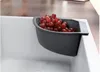 A gray basin filled with red grapes sits on the edge of a white sink. Produktbild-Vorschau