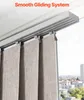 A close-up view of a smooth gliding system for vertical blinds, with the blinds hanging down and a cityscape visible through the window in the background. Voir les images du produit