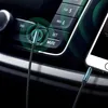 A close-up shot of a car's dashboard with an AUX cable plugged into the car's audio system and a smartphone. Produktbild-Vorschau