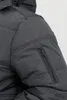Close-up of a dark gray jacket sleeve showing a zippered pocket. Produktbild-Vorschau