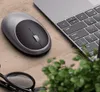 A wireless mouse and laptop keyboard on a wooden desk, with glasses and a plant in the foreground. Anteprima dell’immagine prodotto