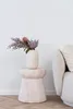 A vase with flowers on a side table next to a sofa. Podgląd zdjęcia produktu