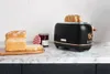 A black and copper toaster with bread and jam on a marble countertop. Voir les images du produit