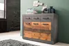 A modern sideboard with a concrete-look frame and wooden front panels, decorated with books, a vintage fan, and a decorative vase. Produktbild-Vorschau