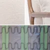 A collage of three close-up images showing the texture of a cream bouclé fabric, a wooden armrest of a chair with the fabric, and the internal spring suspension system of a chair. Produktbild-Vorschau