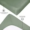 Close-up views of a green fitted sheet, highlighting its features. Produktbild-Vorschau
