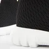 A close-up view of the sole and lower part of a black knit shoe. Produktbild-Vorschau