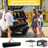 People loading a folded tent into the trunk of a car. Náhled obrázku produktu
