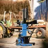 A blue and black log splitter is shown outdoors in a yard with a tractor and trailer in the background. Produktbild-Vorschau