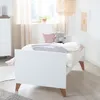 A child's bedroom with a white crib and bedding. Produktbild-Vorschau