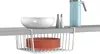 A white wire hanging basket filled with orange plates is shown under a gray shelf. On the shelf are a white bowl, two salt and pepper shakers, and a blue pitcher. Náhled obrázku produktu