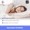 A young woman sleeping peacefully on a bed, covered by white bedding. Produktbild-Vorschau