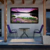An outdoor patio area with a projector screen displaying a landscape image, a table, and two chairs. Voir les images du produit