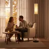A couple enjoys wine in a cozy living room setting, with a floor lamp providing ambient light. Náhľad obrázku produktu