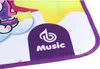 A close-up view of a colorful children's playmat with a unicorn and a purple logo that says 'Music'. Produktbild-Vorschau