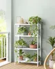 A white shelf unit filled with various potted plants on a wooden floor, next to a balcony railing. Náhled obrázku produktu
