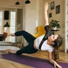 A woman is doing a side plank exercise on a yoga mat in a living room. Anteprima dell’immagine prodotto