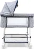 A baby bassinet with a canopy and storage basket, shown from the side against a white background. Náhled obrázku produktu