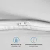 A close-up view of a white zipper on a white fabric surface, with two informational icons and text below. Produktbild-Vorschau