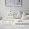 A cozy indoor reading nook with a hanging chair, pillows, and books. Produktbild-Vorschau