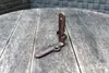 A single corner bracket sits on a weathered wooden surface. Produktbild-Vorschau