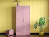 A pink metal cabinet stands in a room with yellow paneled walls. A plant is on top of the cabinet, and another plant is to the right. A wicker basket with books is on the left. Voir les images du produit