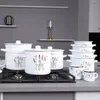 A set of white enamel pots with a lavender design, displayed on a stovetop. Produktbild-Vorschau