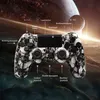 A video game controller with a skull pattern is shown against a cosmic background with planets. Produktbild-Vorschau