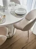 A dining table set with chairs and tableware in a bright, modern setting. Produktbild-Vorschau