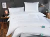 A neatly made bed with white bedding, including a duvet and pillows, in a bedroom setting. Produktbild-Vorschau