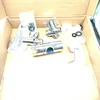 Various plumbing components are laid out inside a cardboard box. Produktbild-Vorschau