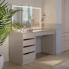 A modern dressing table with a lighted mirror and drawers, set in a well-lit room with a plant and a wardrobe in the background. Produktbild-Vorschau